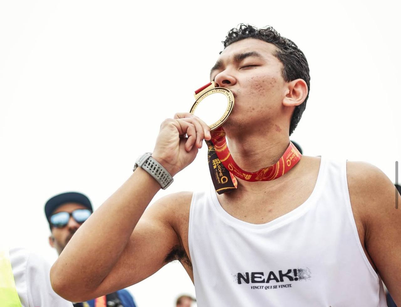 Christopher Chea kissing his finisher medal